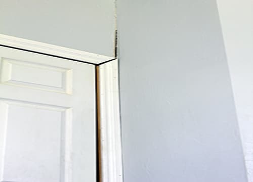 Gap opening between a door frame and the wall