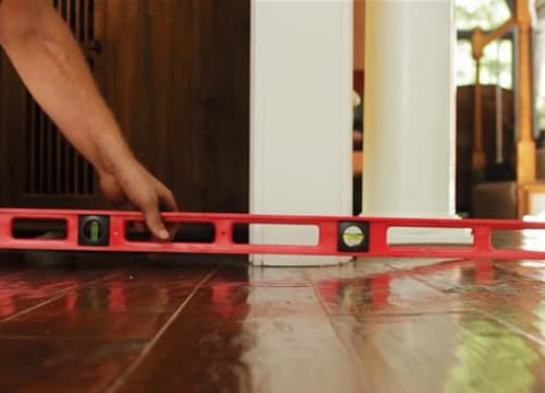 Level showing a sloping hardwood floor